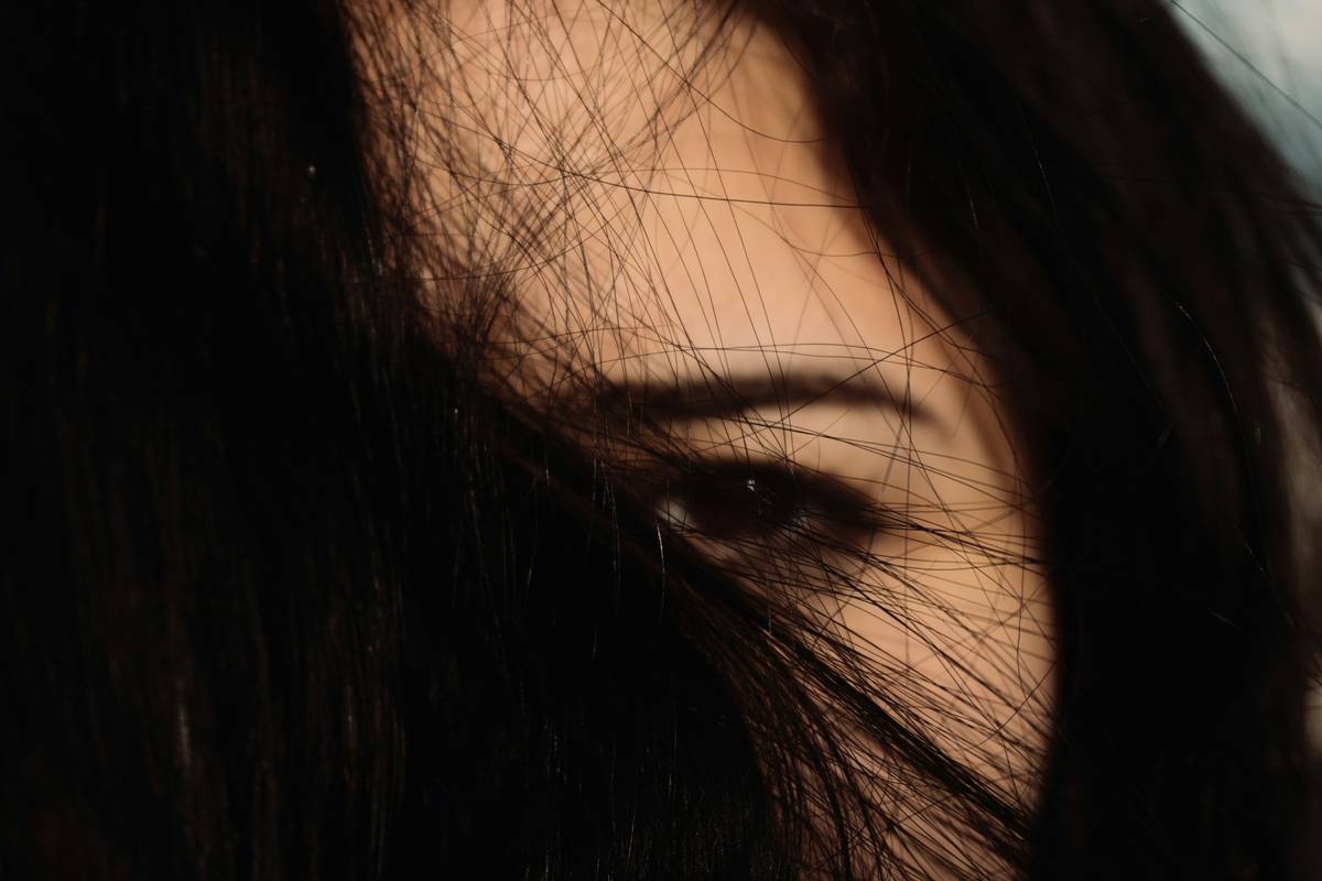 Professional stylist applying lowlight styling artistry with hand-painted balayage technique on brunette hair